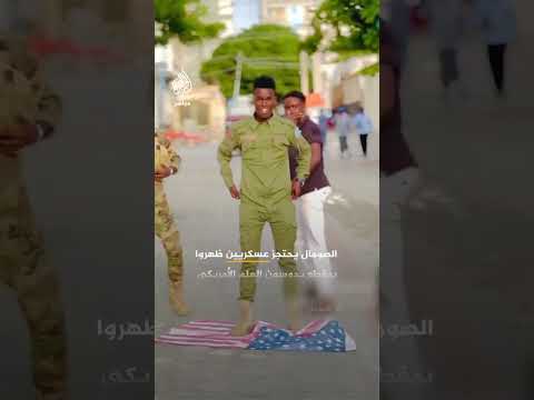 مشاهد تظهر أشخاصا يرتدون الزي العسكري الصومالي وهم يضعون العلم الأمريكي على الأرض ويدوس أحدهم عليه